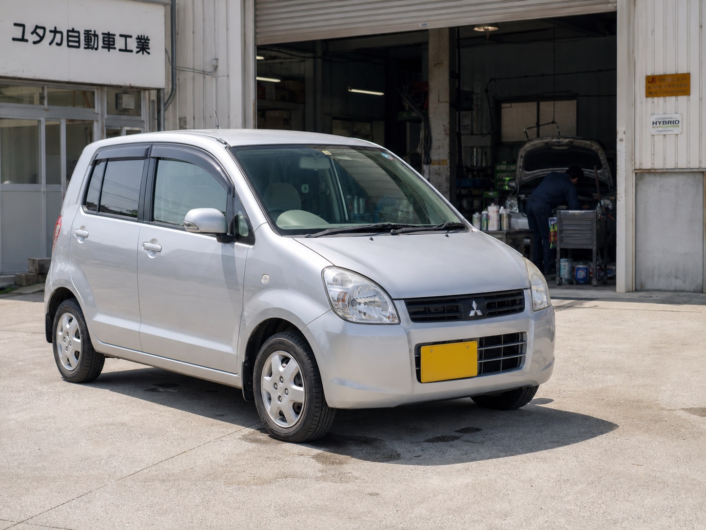 ユタカ自動車工業の工場前に停められた silver の軽自動車